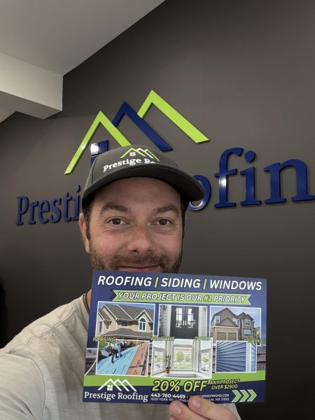 Prestige Roofing staff member smiling and displaying a special offer flyer for roofing services