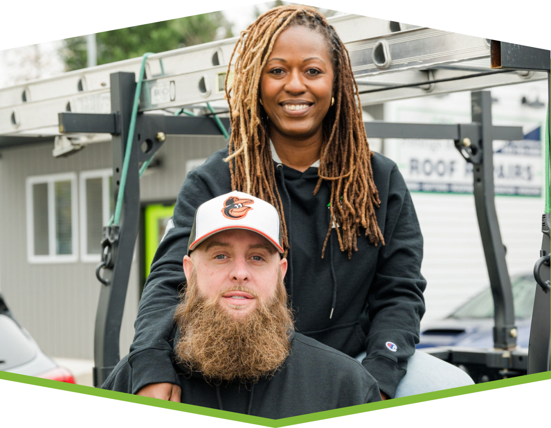 Prestige Roofing office photo featuring two smiling colleagues standing together on the job site